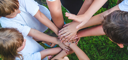 Children are playing with their hands clasped together